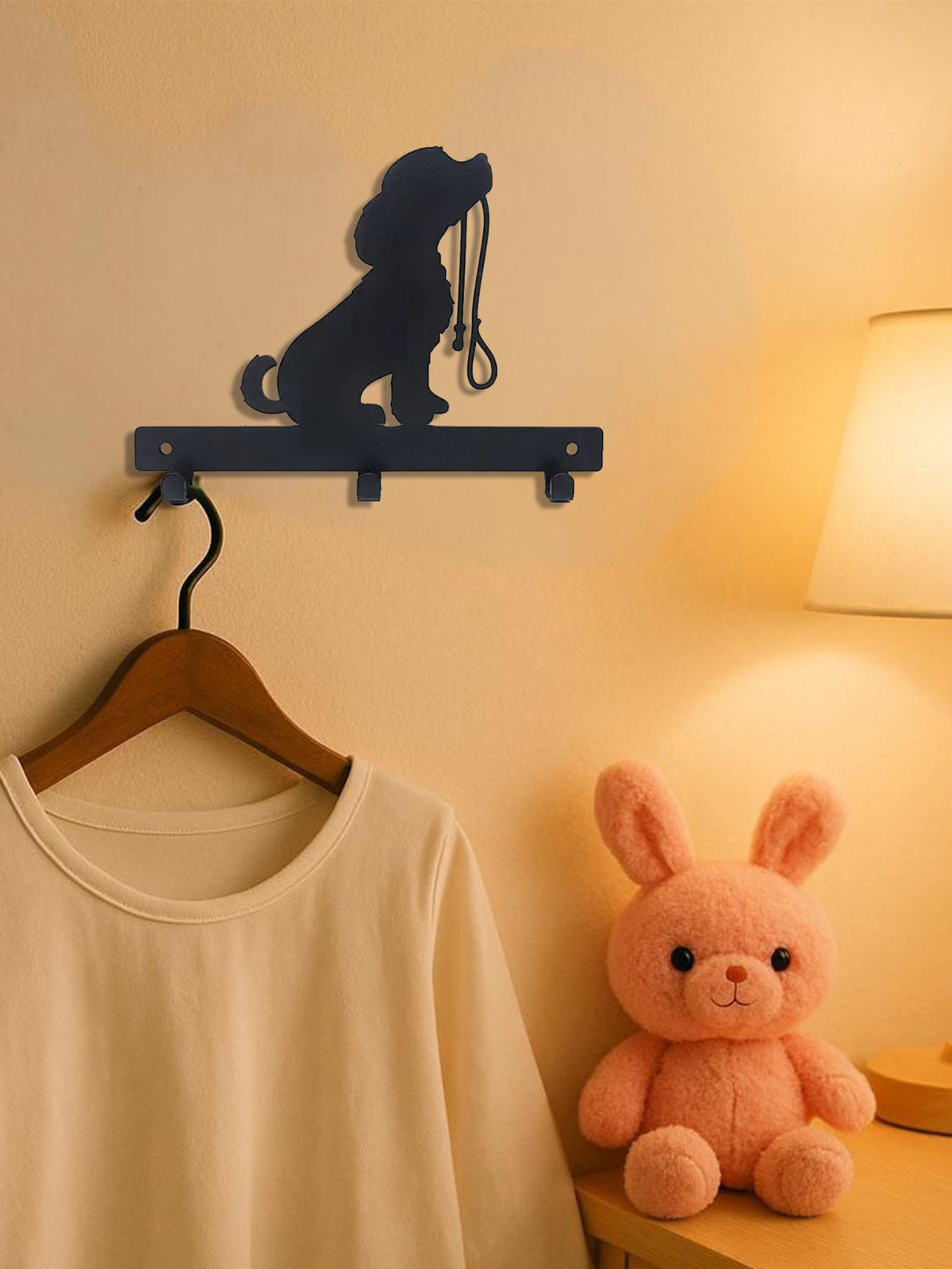 Dog silhouette hook rack in a bedroom holding a clothes hanger